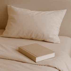 Beige book on a bed with a pillow in the background | Sanggolcomfort.com
